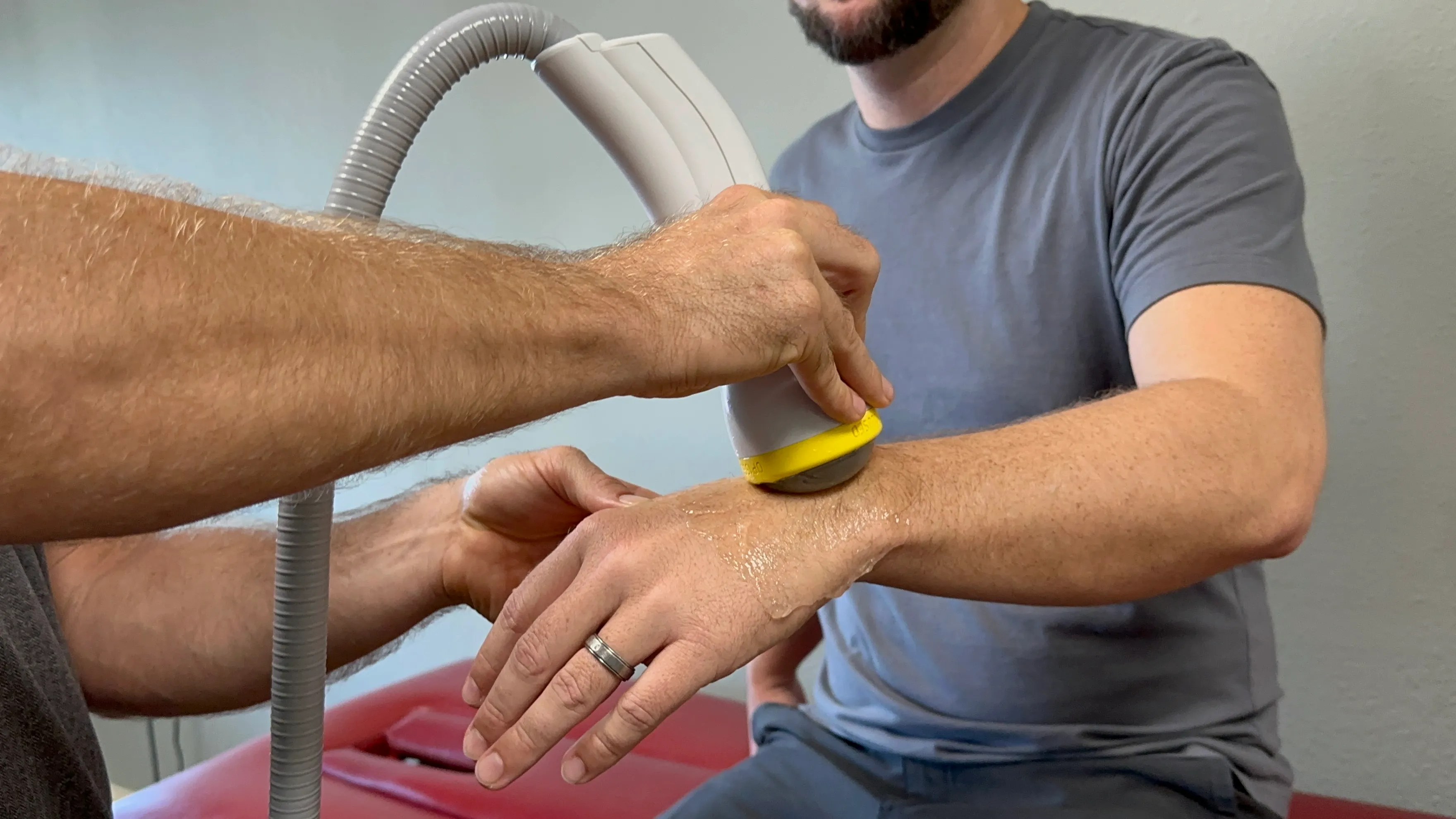 A provider applying the ShockWave handheld applicator to a patient's wrist